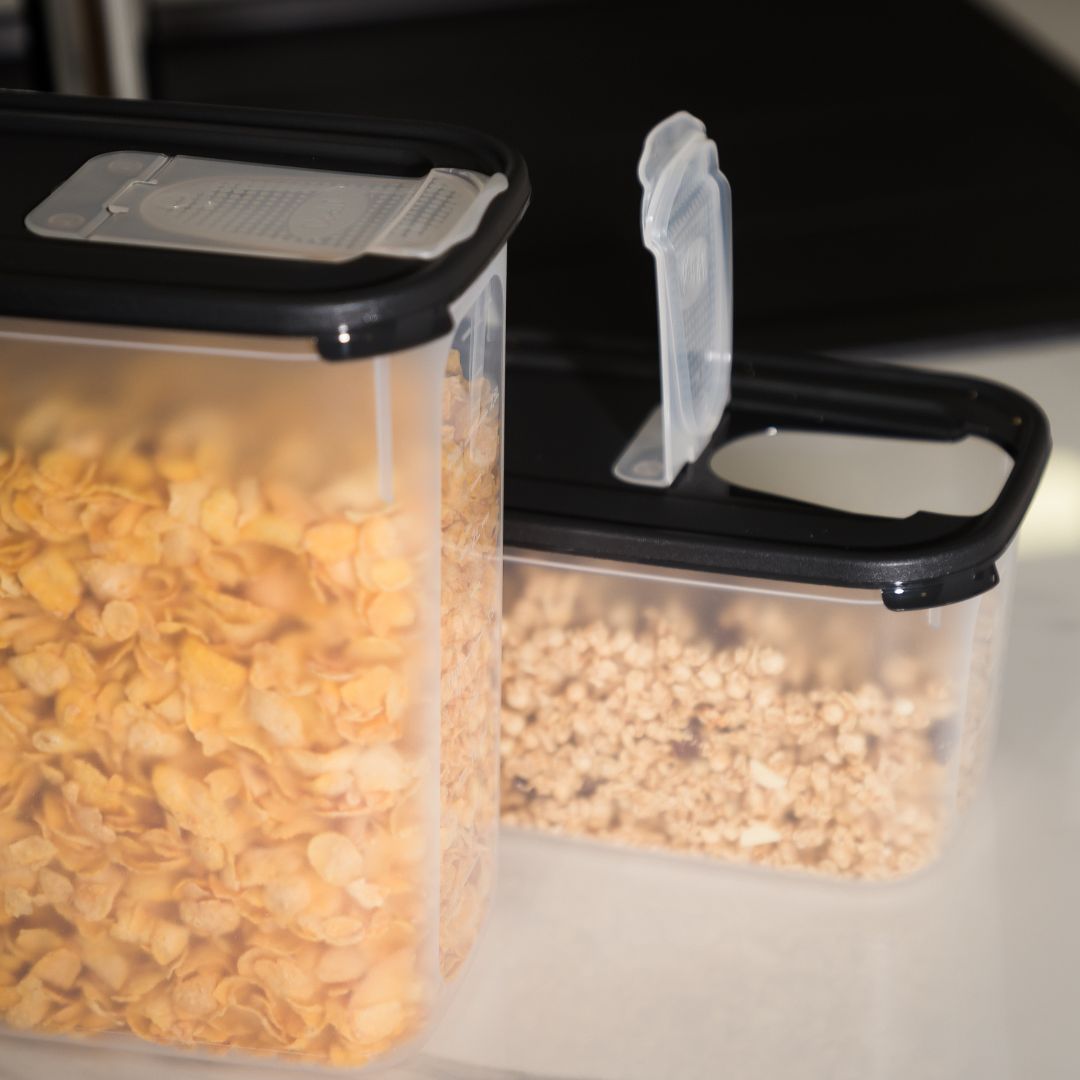 Foto contexto de recipientes com dispensador, em dois tamanhos, o menor com tampa aberta com cereais dentro