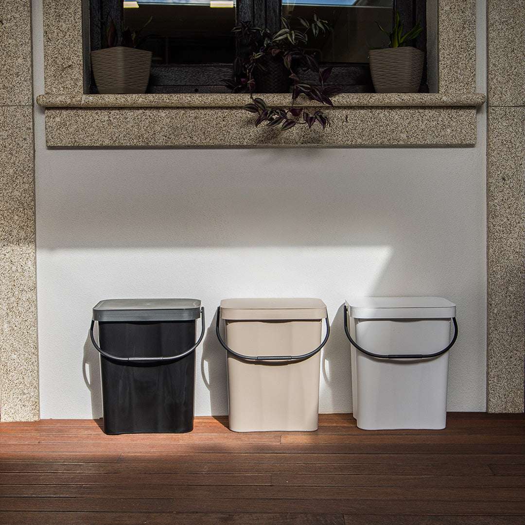 3 caixotes do lixo com asa no exterior, em preto, bege e branco